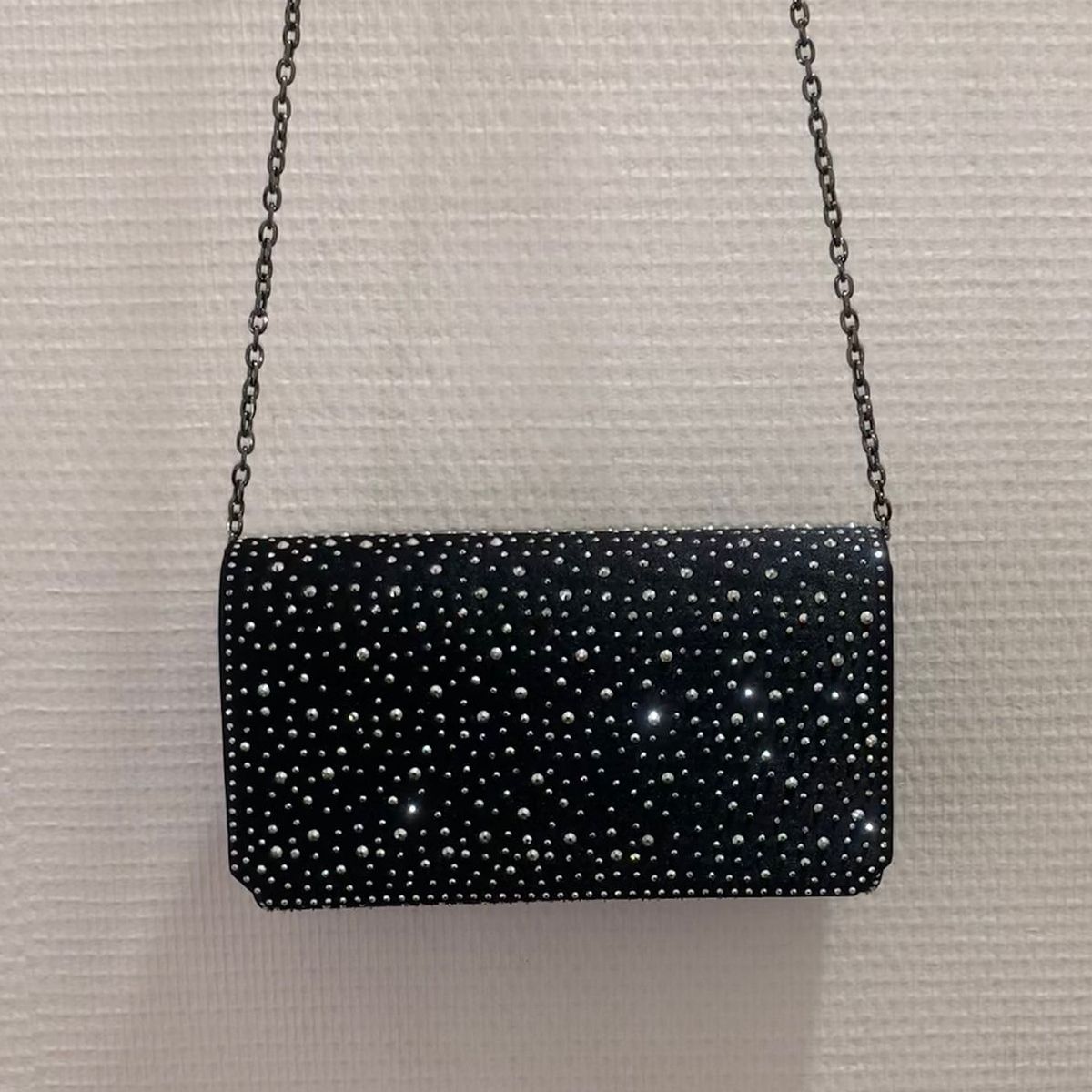 Zwarte envelop clutch met sprankelende kristallen, hangend aan de ketting