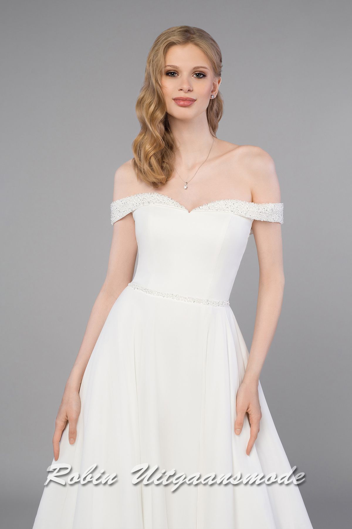 Close-up van de Trouwjurk met glitter off-shoulder halslijn, aansluitend lijfje met vetersluiting en A-lijn rok met split