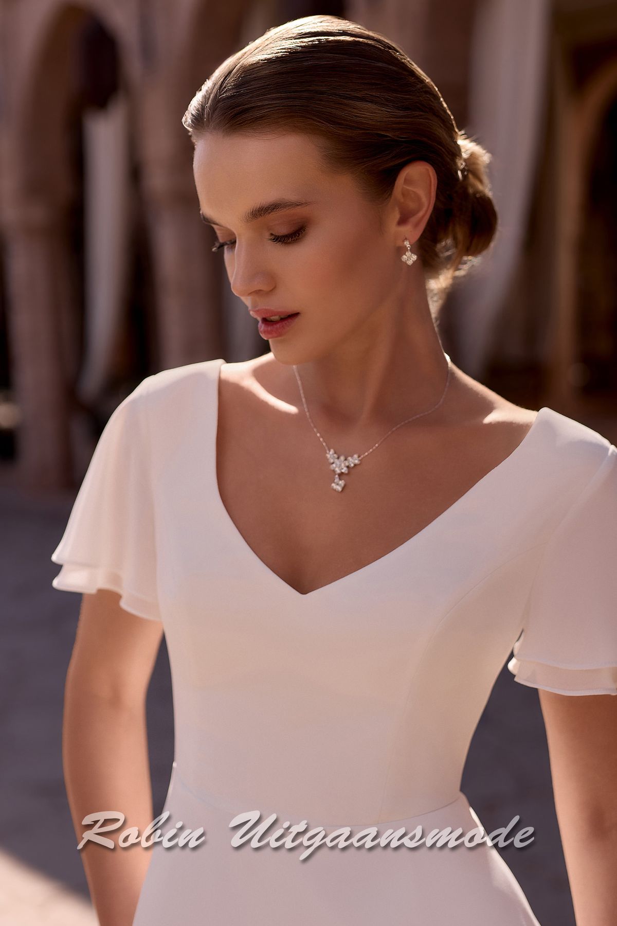Close-up van de A-lijn trouwjurk met chiffon korte mouwtjes en V-hals