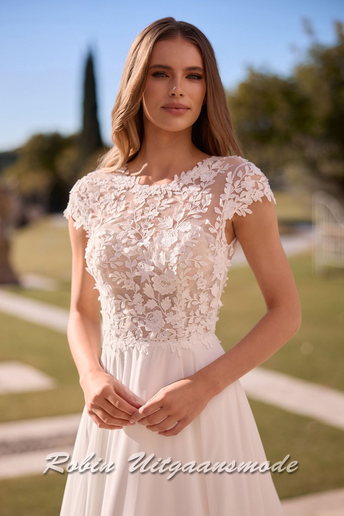 Close-up van de Romantische A-lijn bruidsjurk met kanten lijfje met boothals, kapmouwtjes en chiffon rok met ronde sleep