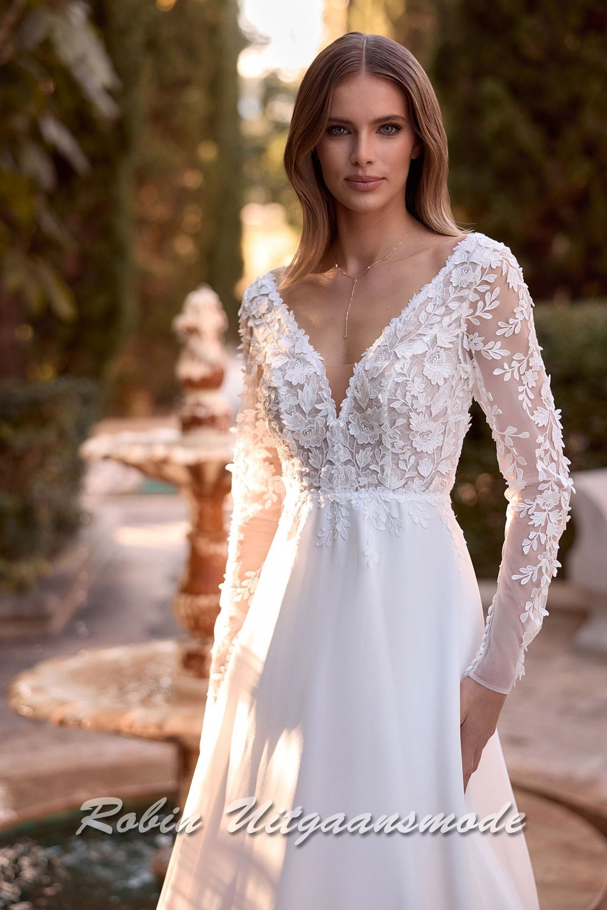 Close-up van de Romantische bruidsjurk met kanten lijfje, lange mouwen en een chiffon A-lijn rok met bescheiden sleep