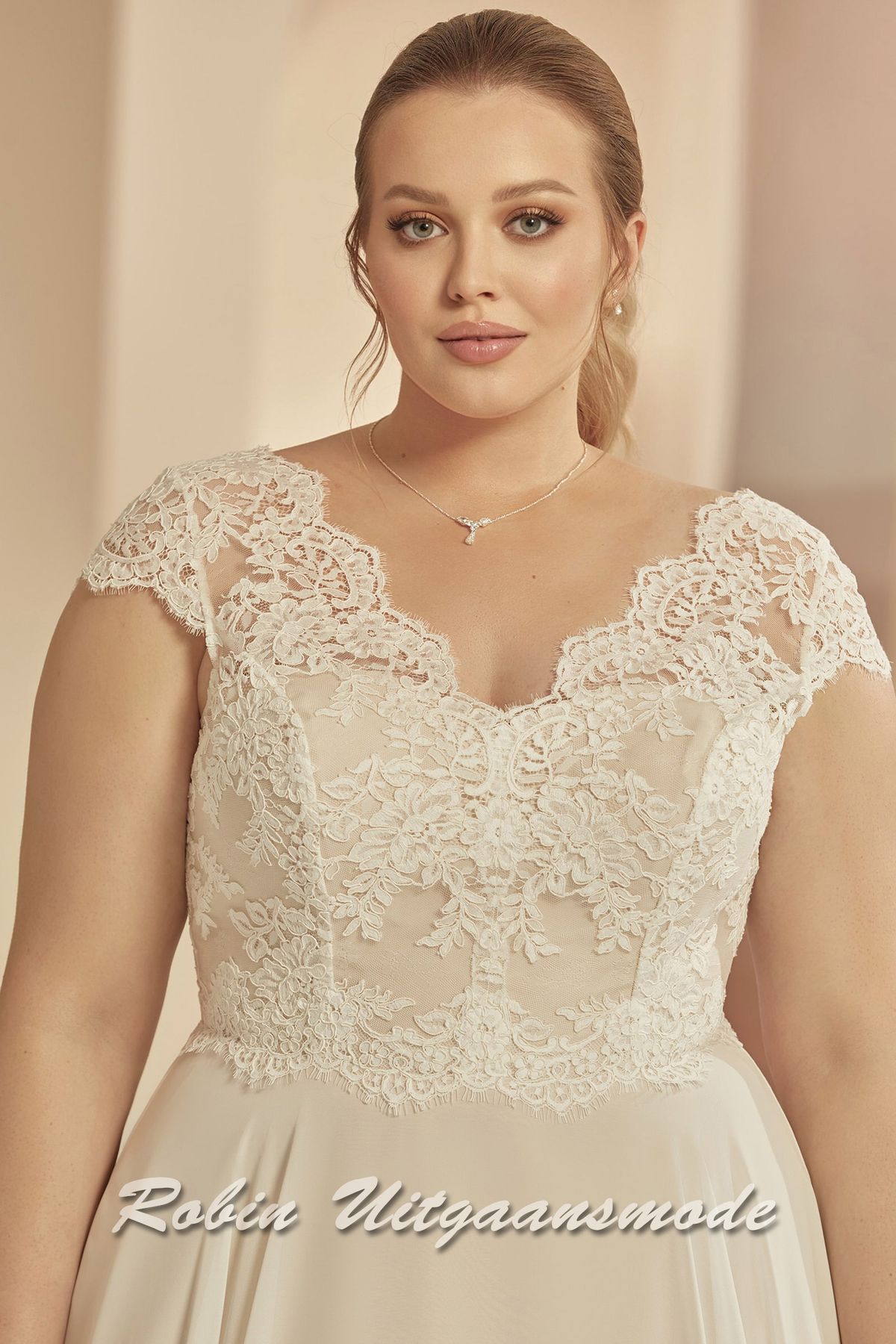 Close-up van de Plus-size trouwjurk met A-lijn rok en kapmouwtjes van kant