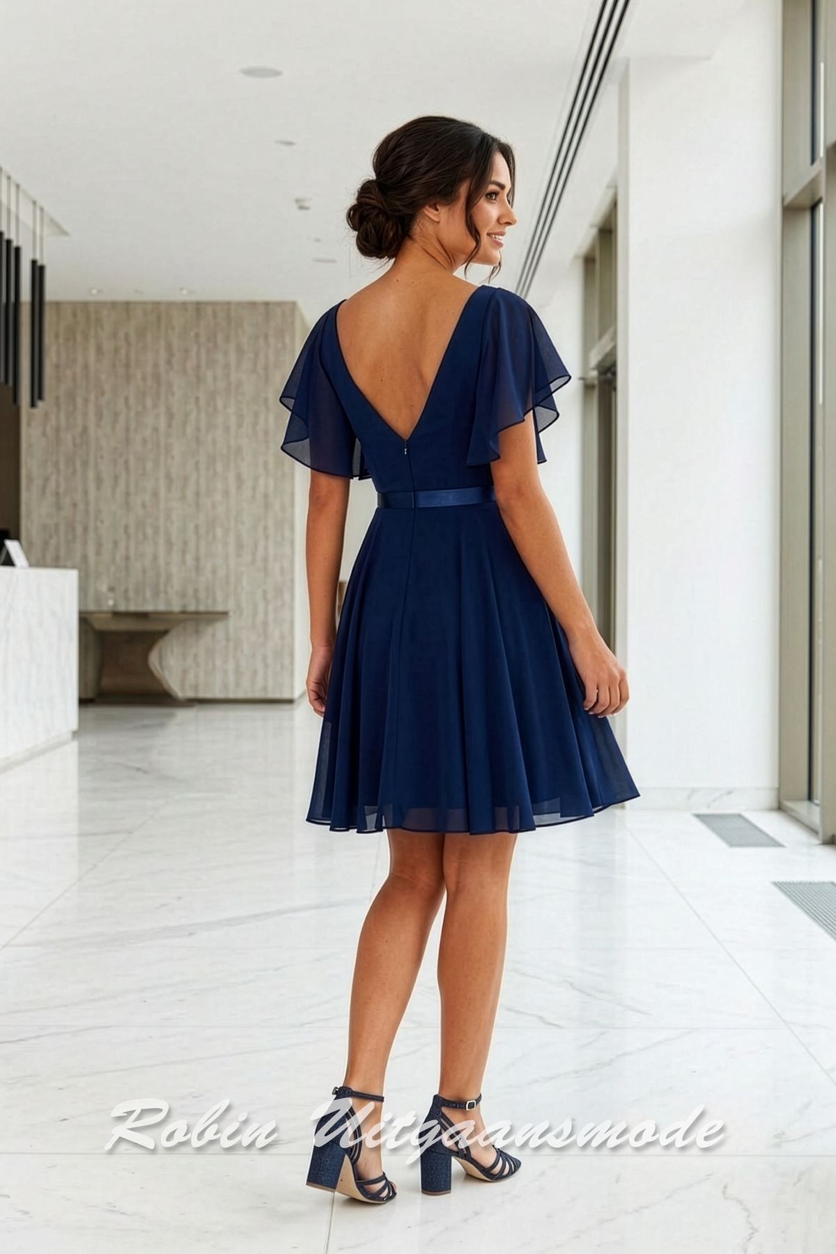 Achterkant van de Navyblauw Chiffon cocktailjurkje met geplooide mouwtjes