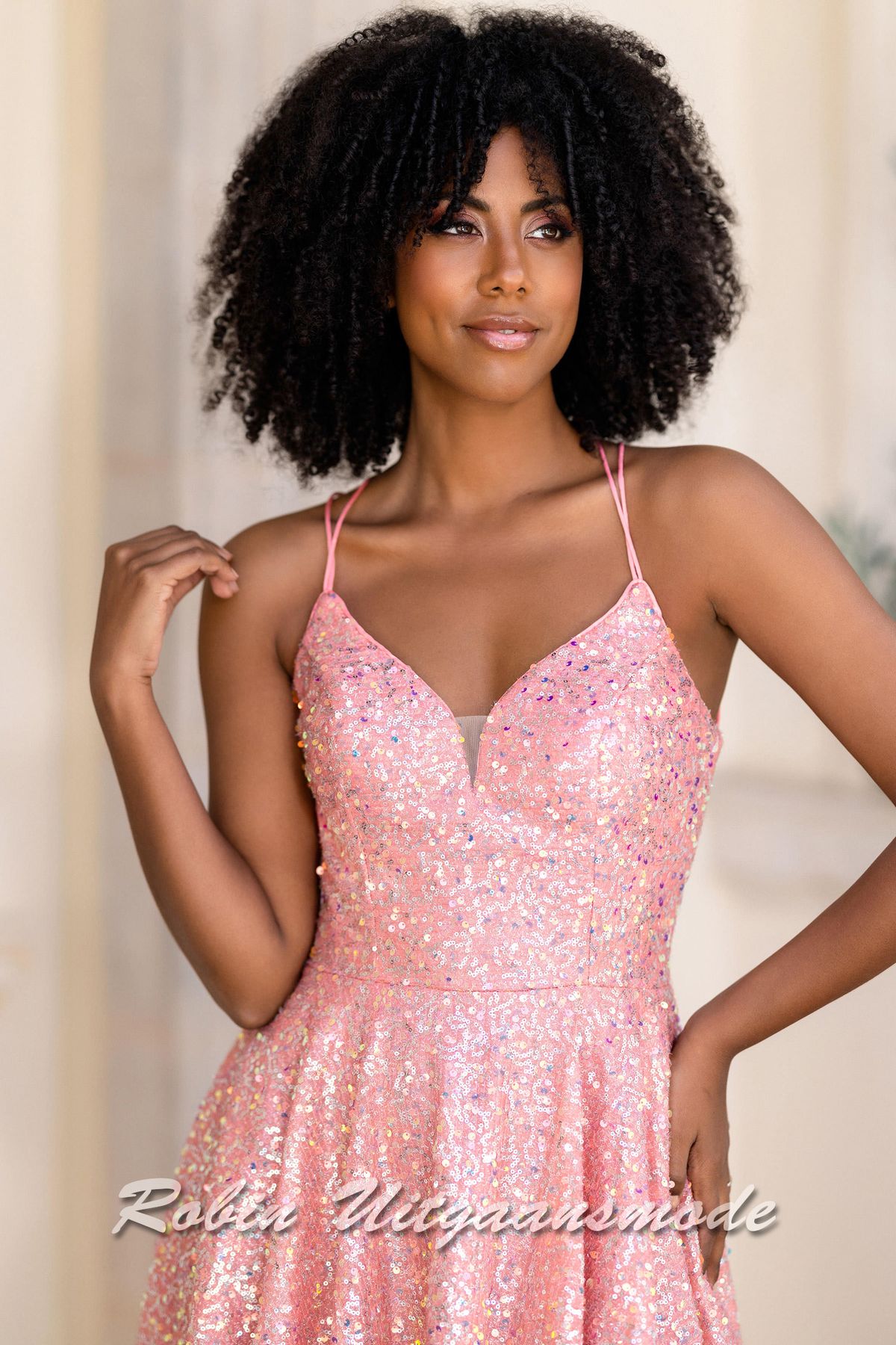 Close-up van de Roze pailletten cocktailjurk met lage rug, een heartshape halslijn en licht geplooide rok met asymmetrische lengte