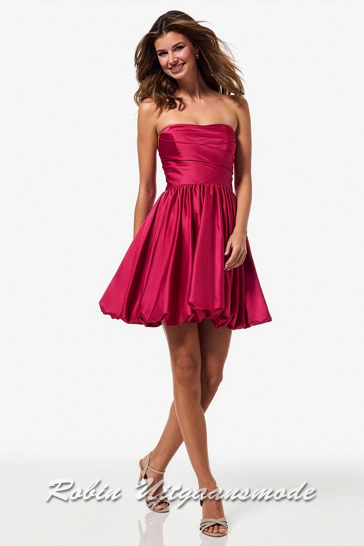 Framboos gekleurde cocktailjurk met een geplooide ballon rok tot ruim boven de knie en strapless top met schuinlopende banen