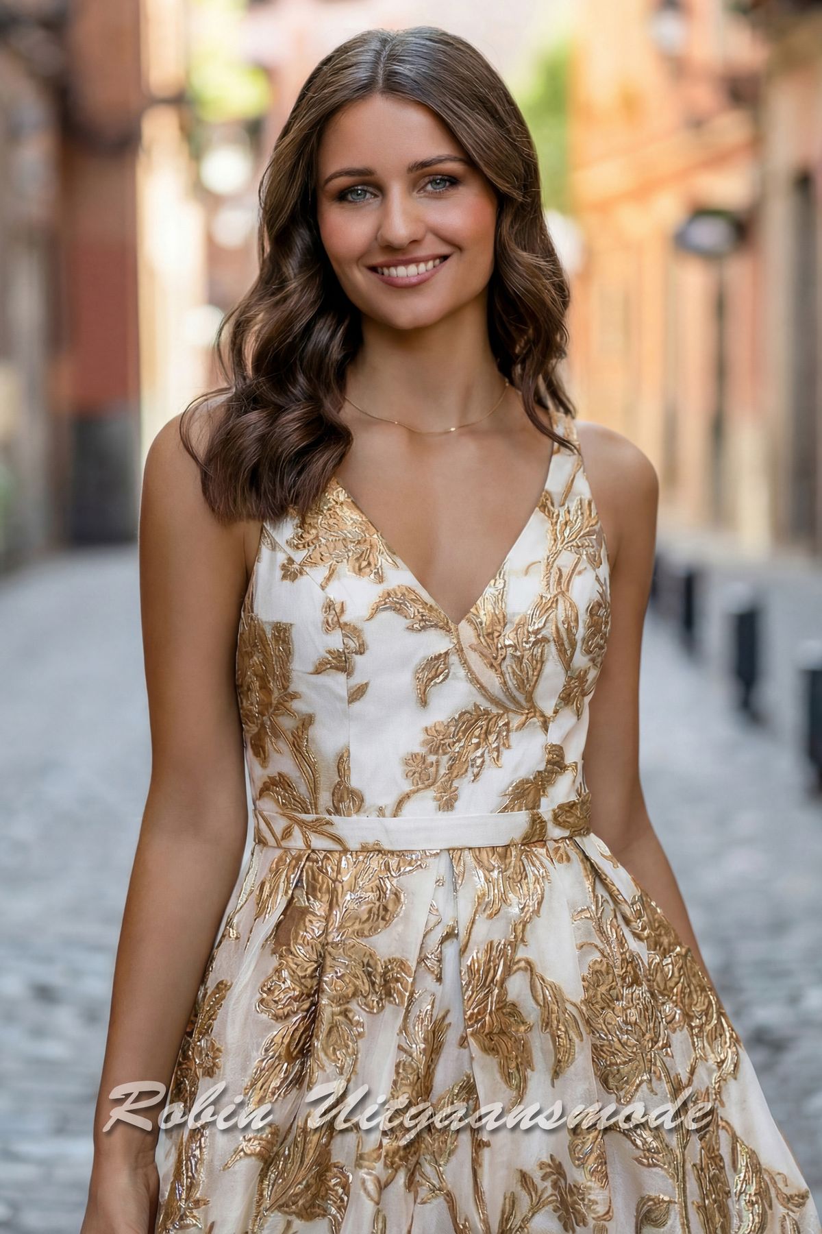 Close-up van de A-lijn brocade avondjurk met champagne goudkleurige bloemenpatroon, een V-hals en smalle tailleband