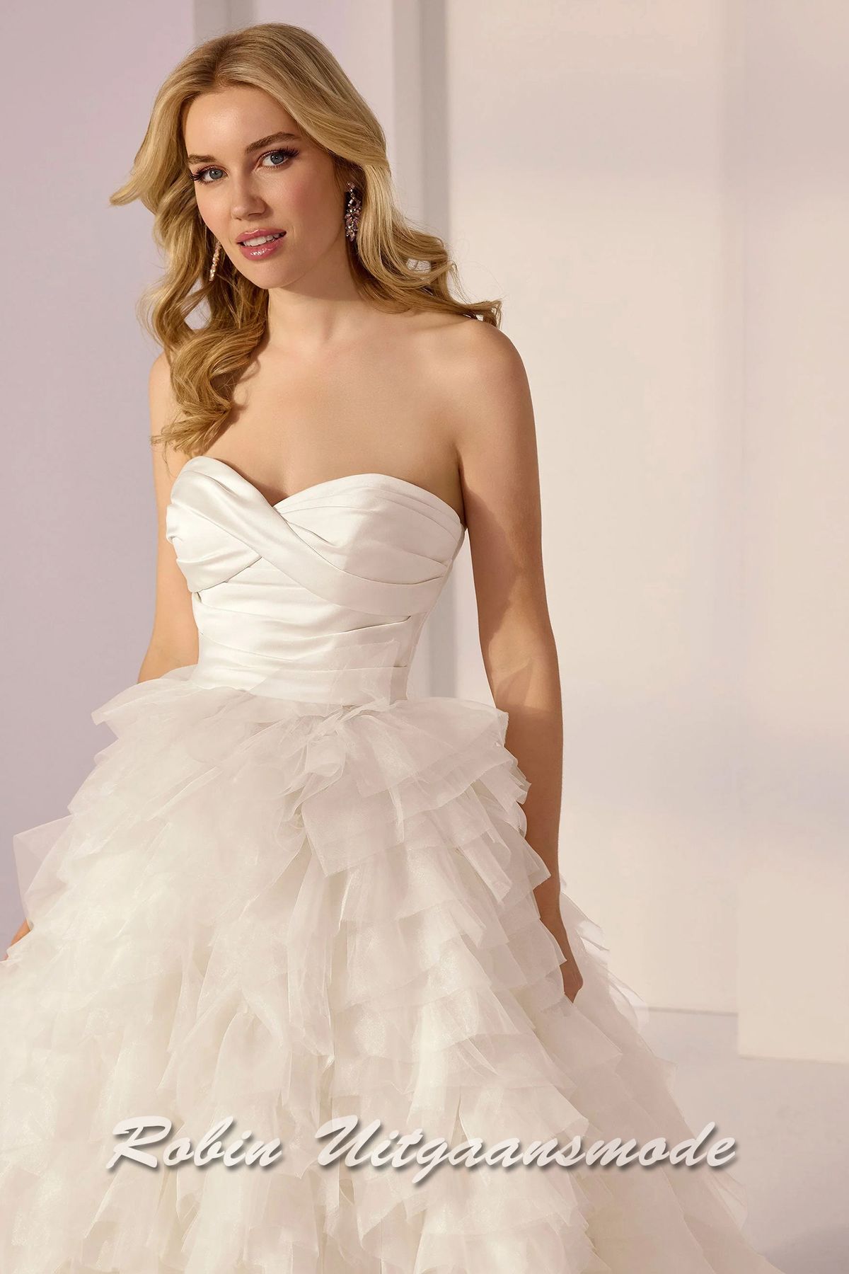 Ivoorkleurige baljurk met strapless lijfje met sweatheart hals lijn, gedrapeerd satijnen en een geplooide A-lijn rok met een cascade van lagen tule en organza