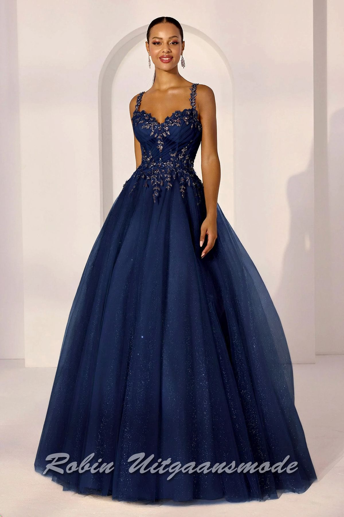 Navy blauwe baljurk met bloemen versierd korset lijfje, een sweatheart halslijn en een volle A-lijn rok  met toplaag van glittertule.