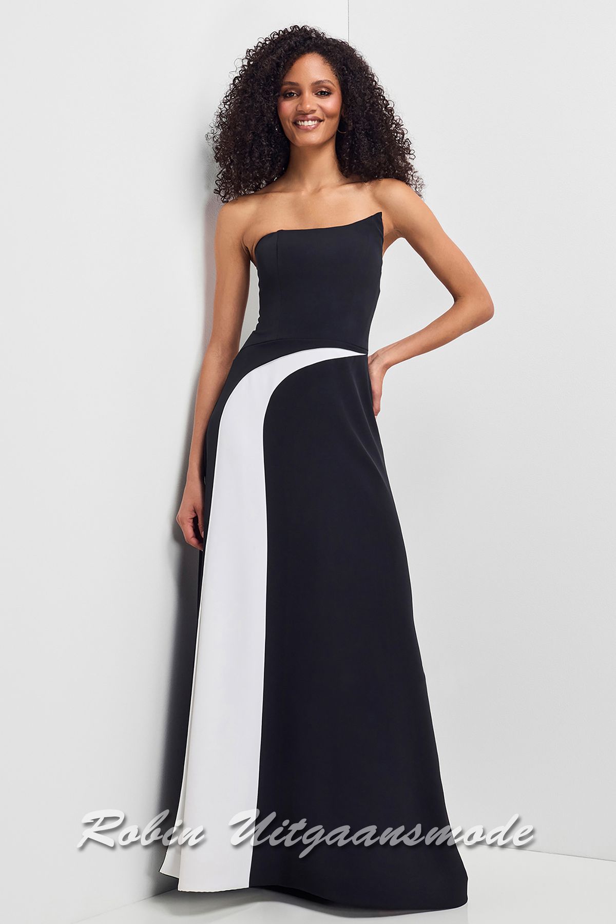 Zwarte avondjurk met asymmetrische witte baan over de rok en een strapless top met spits toelopende uiteinde aan de linkerzijde