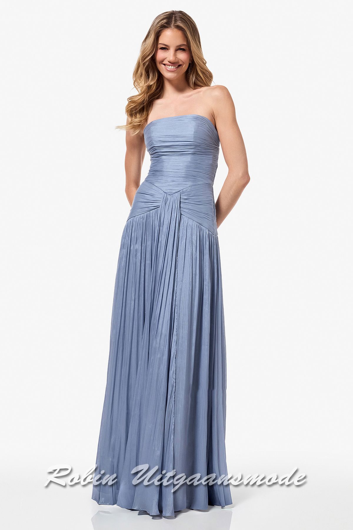 Rookblauwe avondjurk met uniek lijnenspel van smalle plooitjes, een rechte strapless top, taps toe lopende stof in de taille en lange rok tot de grond