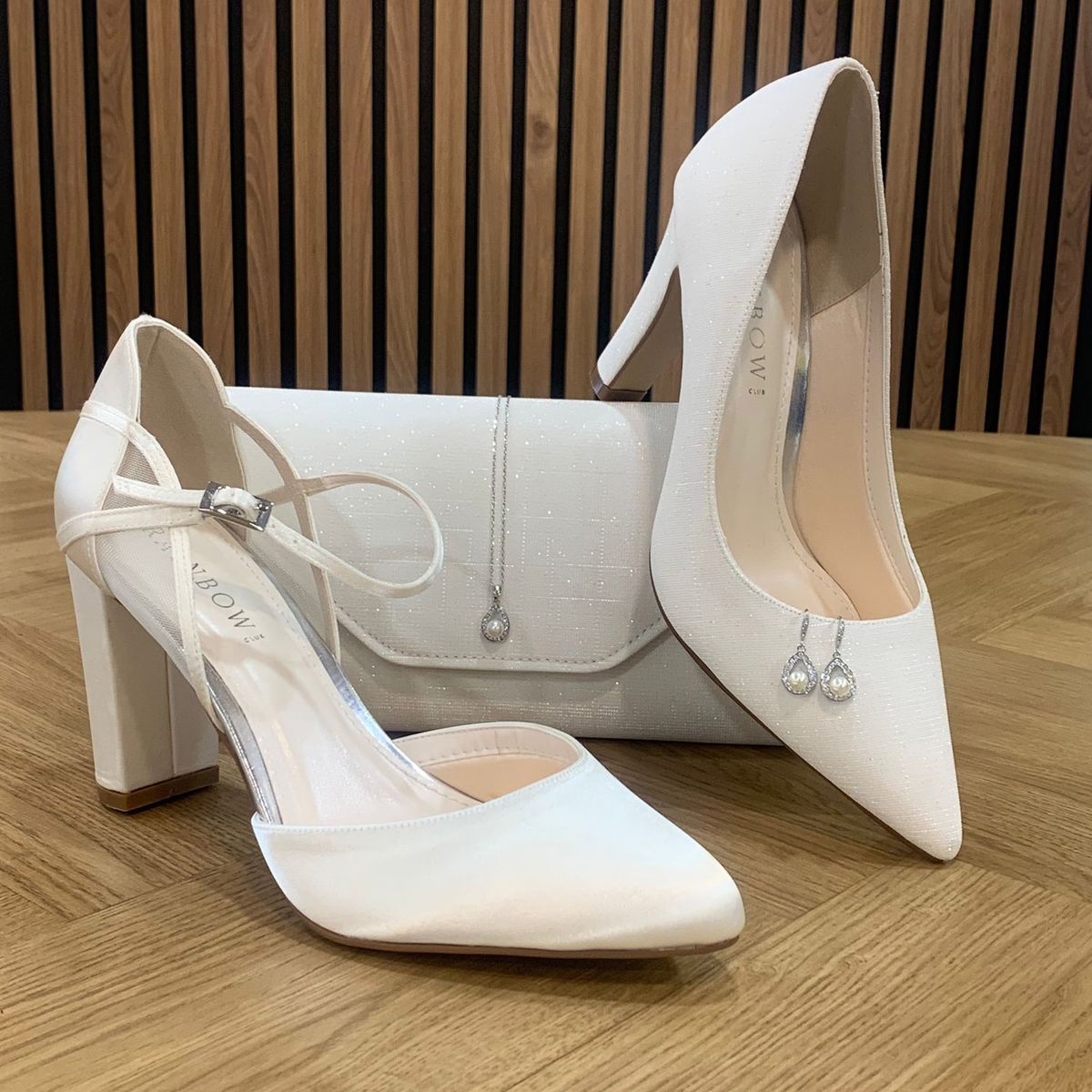 Ivoorkleurige accessoires om je bruidslook mee af te stijlen, bruidsschoenen, zilverkleurige ketting met parel hangers en bruidstasje