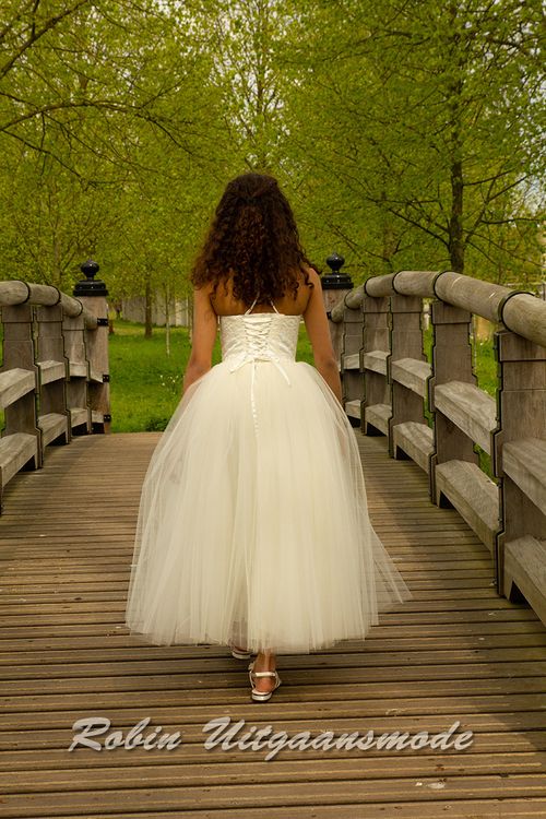 Achterzijde van de Bruidsmeisjesjurk met een kanten lijfje, sierlijke vetersluiting en lange rok met meerdere tule lagen.
