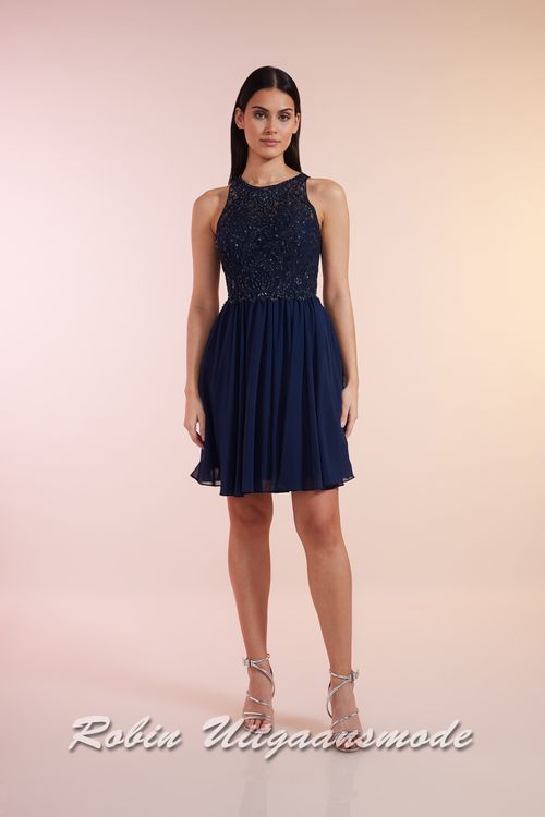 Navy blauwe cocktailjurk met hooggesloten kanten lijfje, blote schouders en een geplooide chiffon rok tot net boven de knie