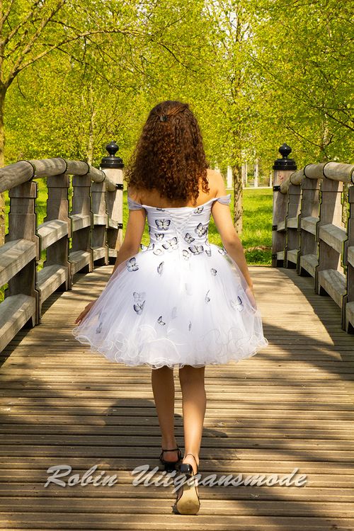 Achterkant van de Feestelijke jurkje van vrolijke vlinderstof, met strapless lijfje, afhangende schouders en wijde tule rok.