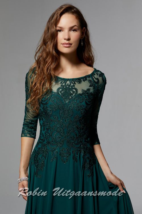 Close-up van de Smaragdgroene avondjurk met driekwart lange mouwen, boothals, een geborduurd lijfje met kristallen en een chiffon rok