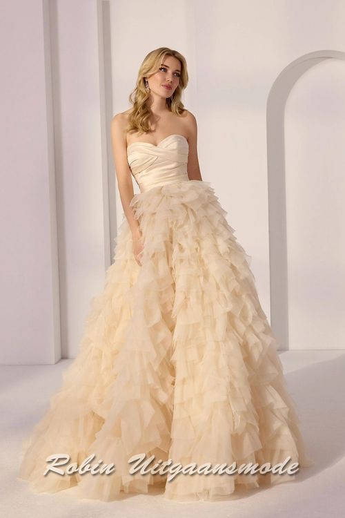 Champagnekleurige baljurk met strapless lijfje met sweatheart hals lijn, gedrapeerd satijnen en een geplooide A-lijn rok met een cascade van lagen tule en organza