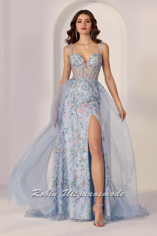 Lichtblauwe galajurk volledig versierd met geborduurde bloemen, pailletten, een korset lijfje met diep uitgesneden bustelijn, lange rok met hoge split en een organza overrok