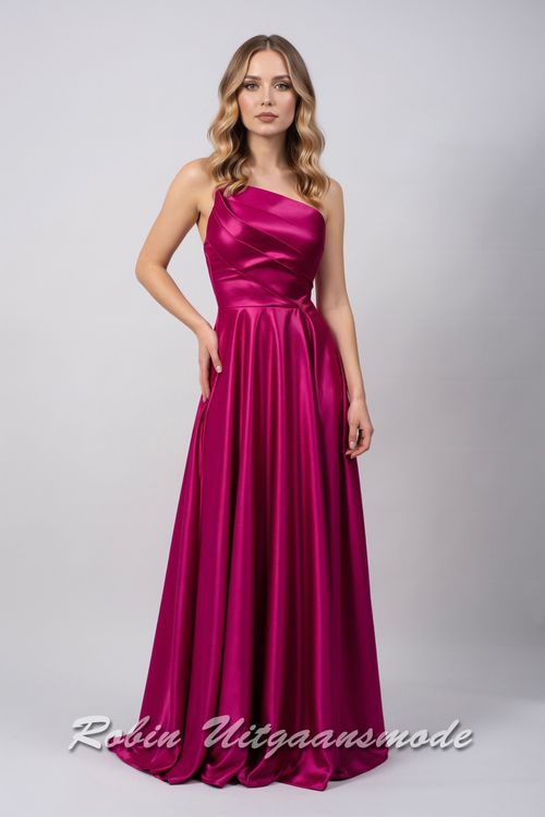 Magenta avondjurk met strapless asymmetrische halslijn, brede banden schuin over de buste lopend naar de linkertaille en licht geplooide rok tot op de grond
