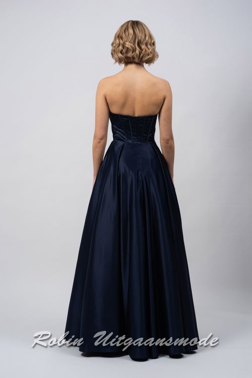 Achterkant van de Strapless inktblauwe avondjurk met A-lijn rok, een heartshape bustelijn versierd met sprankelende pailletten en afgewerkt met waterval band