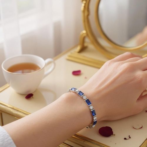 Smalle armband met saffierblauwe en heldere geslepen kristallen, gedragen om de pols van een model