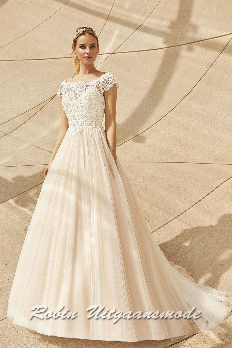 Wijde trouwjurk met tule rok en hartshape lijfje met boothals en kapmouwtjes van transparant kant.