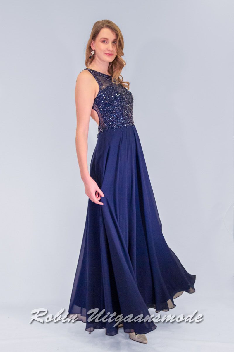Lange avondjurk met chiffon rok en een hooggesloten halslijn, het lijfje versierd met gekleurde kraaltjes en heeft een open rug.
